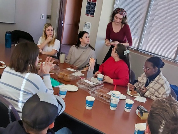 Group of students gathered around a conference table for a meal