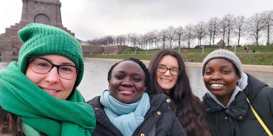 Four young women wearing coats and scarves in Germany