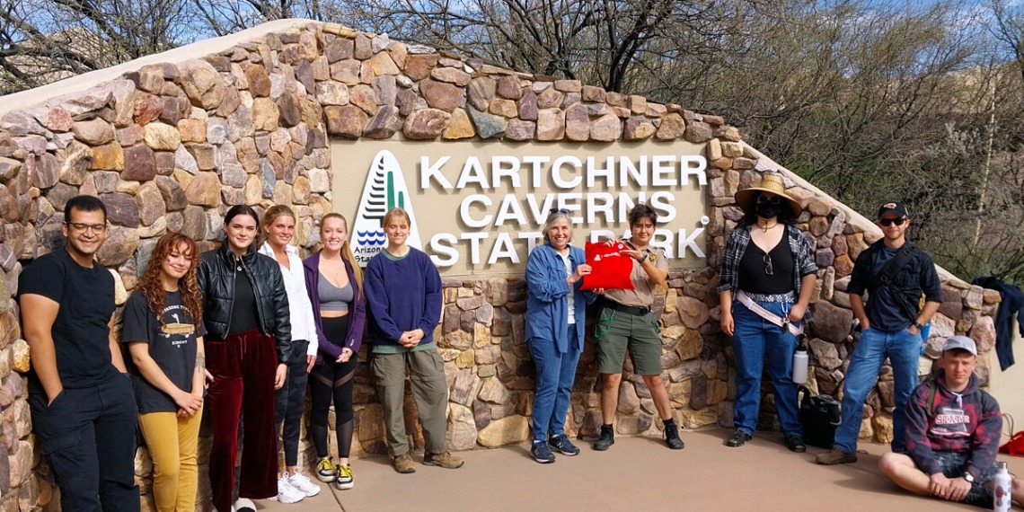 Students and faculty in front of Kartchner Caverns sign